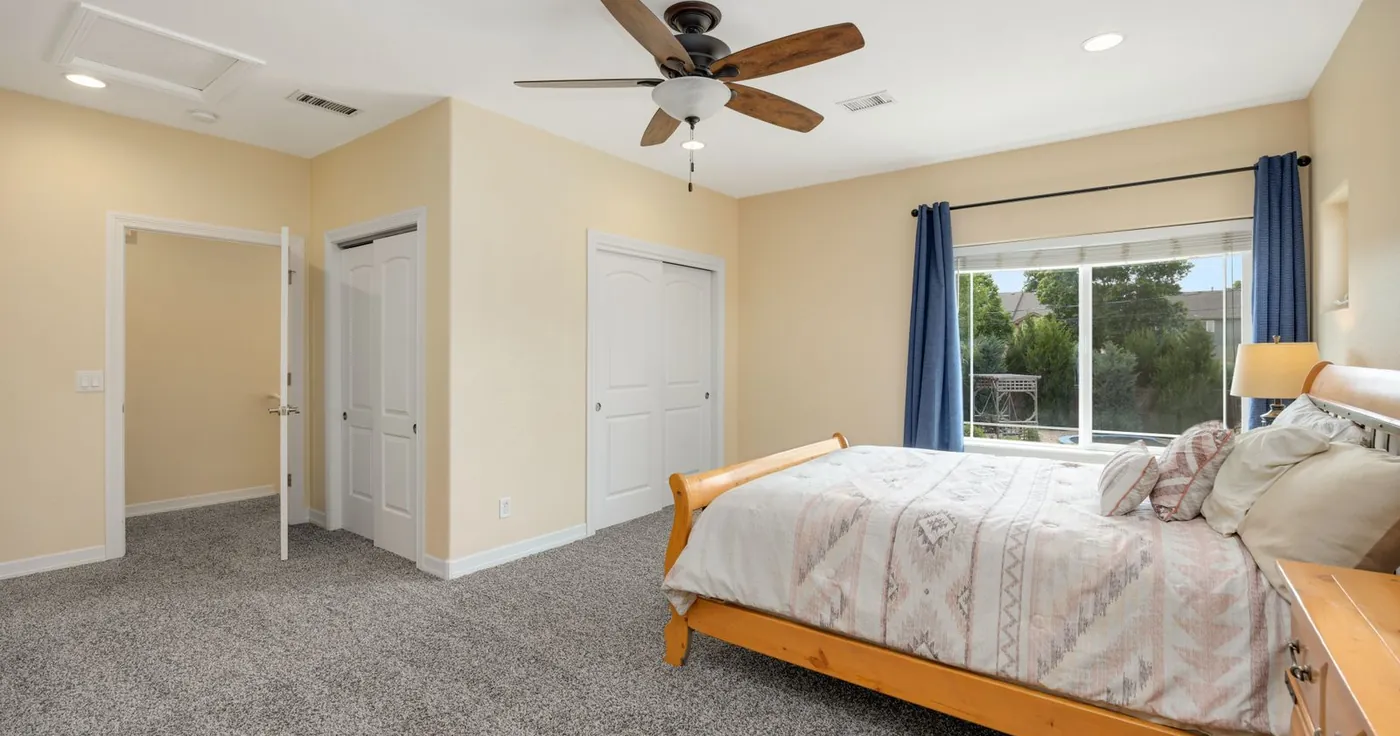 Bright bedroom with a ceiling fan for people sleeping too hot